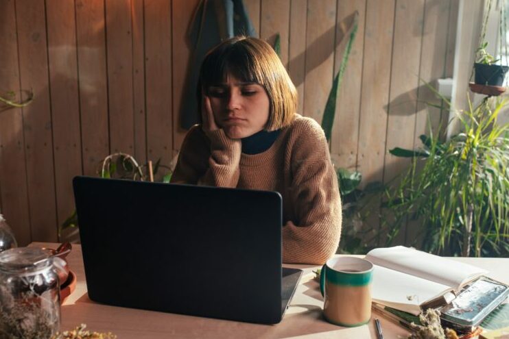 a women bored in front of a laptop